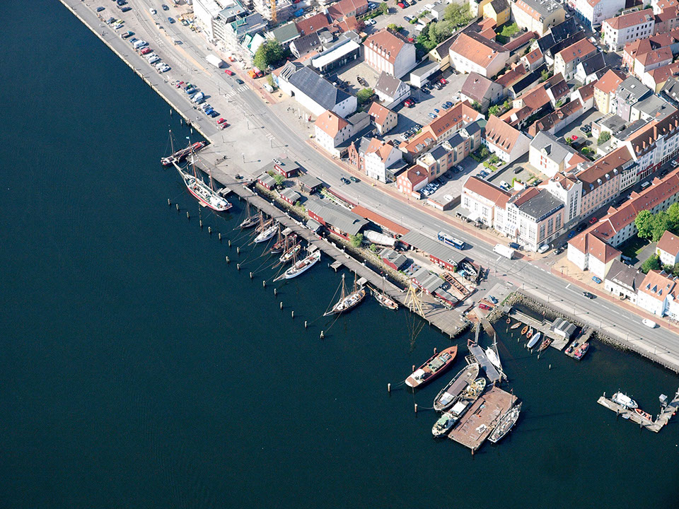 Drohnenbild der Wasserflugstation in Flensburg mit Wasserfluzeug und den Booten aus dem Bootsverleih.
