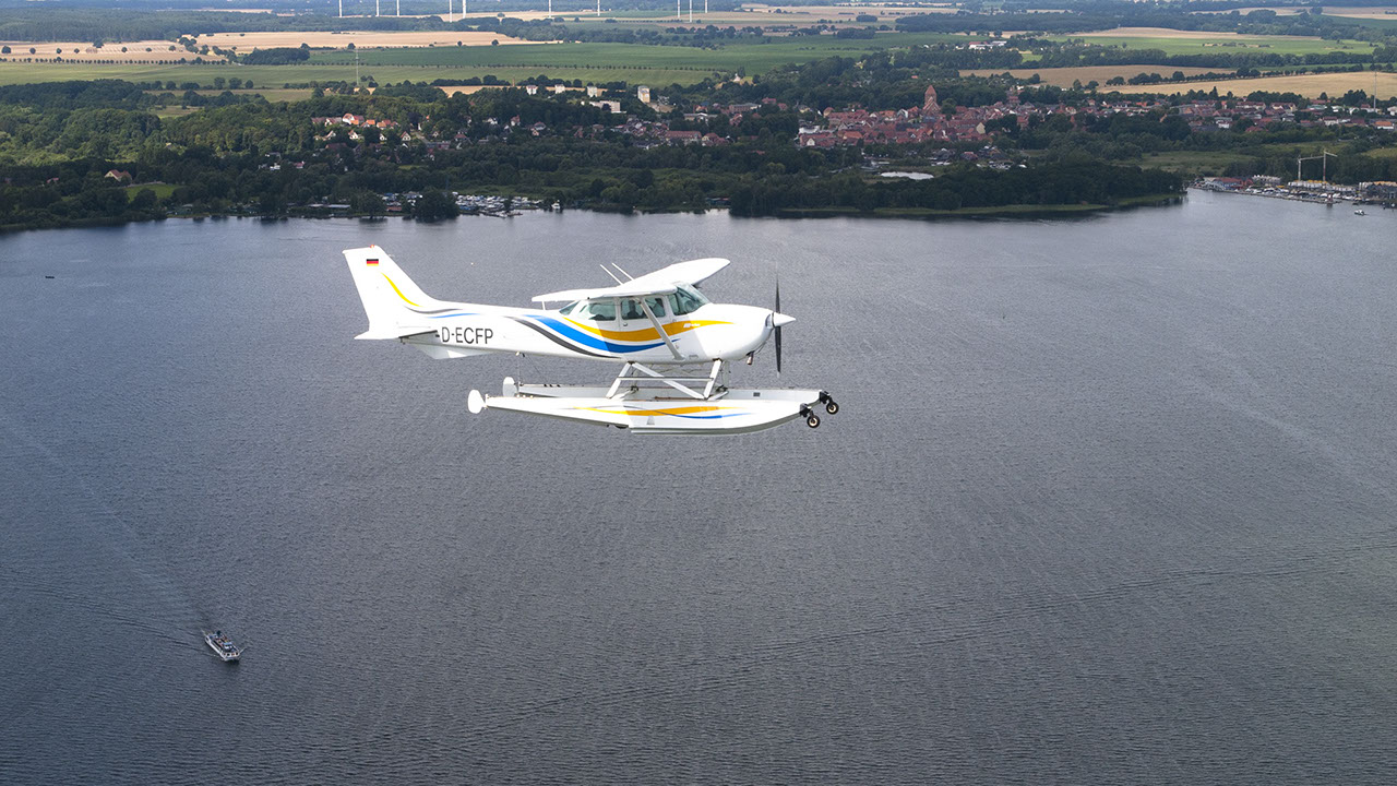 Drohnenbild der Wasserflugstation in Flensburg mit Wasserfluzeug und den Booten aus dem Bootsverleih.