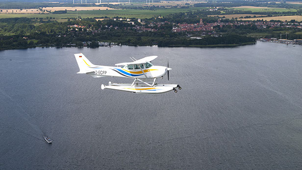 Drohnenbild der Wasserflugstation in Flensburg mit Wasserfluzeug und den Booten aus dem Bootsverleih.