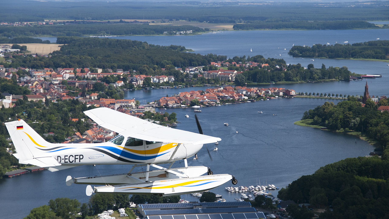 Drohnenbild der Wasserflugstation in Flensburg mit Wasserfluzeug und den Booten aus dem Bootsverleih.