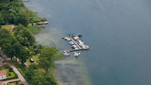 Drohnenbild der Wasserflugstation in Flensburg mit Wasserfluzeug und den Booten aus dem Bootsverleih.