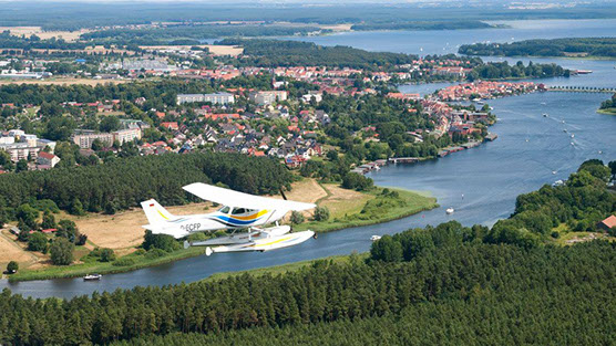 Drohnenbild der Wasserflugstation in Flensburg mit Wasserfluzeug und den Booten aus dem Bootsverleih.